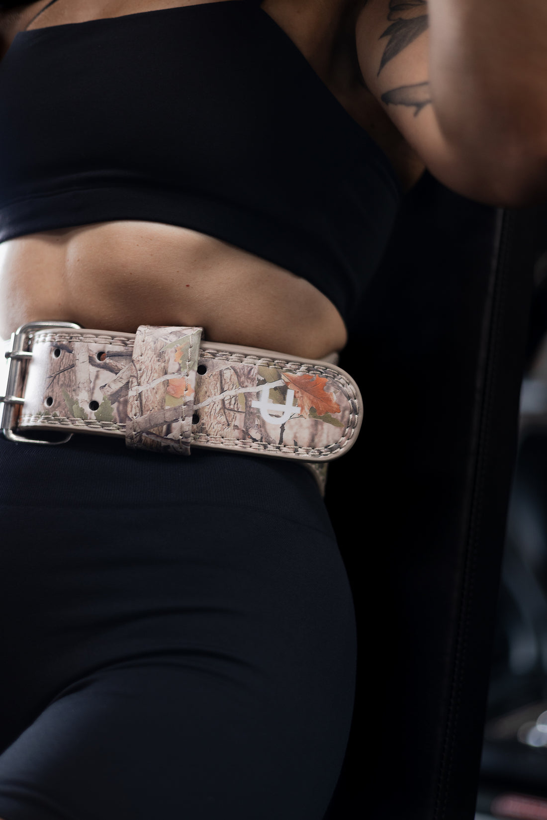 woman lifting with uppper camo lifting belt